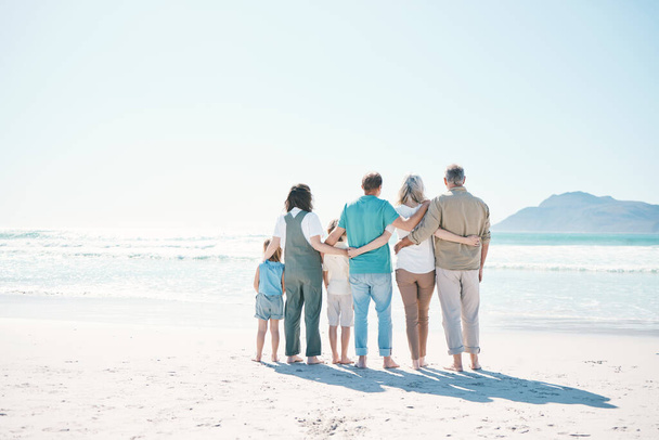 Back, beach and family with love, hug and summer vacation with bonding, support and travel. Grandparents, mother and father with children, embrace or seaside holiday with care, ocean and mockup space. - Photo, Image