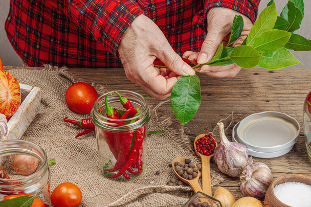 季節の野菜コンセプトを保存しました. トマト,チリ,グリーン,オニオン,ニンニクの収穫. 女性の手は缶詰食品,調理プロセスのための成分を準備します. 健康的なレシピ,家庭料理,コピースペース - 写真・画像