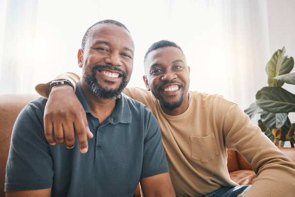 Senior African dad, son and sofa for portrait, hug and smile for love, bonding or care in living room. Mature black man, fathers day and child with happy embrace, relax or excited face in family home. - Photo, Image