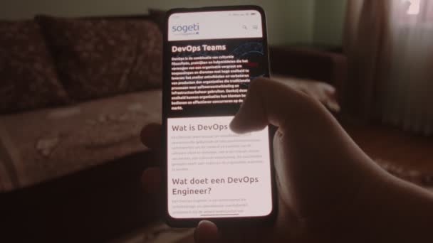 DevOps Takımları. Cep telefonu ekranında DevOps ekipleri hakkında bilgi aranıyor - Video, Çekim