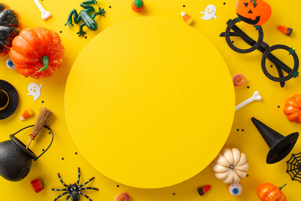 Elragadó halloween cukorka gyűjtemény a gyerekek. Top view kép bemutatása édességek és Halloween dekorációk sárga elszigetelt háttér, sokoldalú szöveg vagy reklám használatra - Fotó, kép