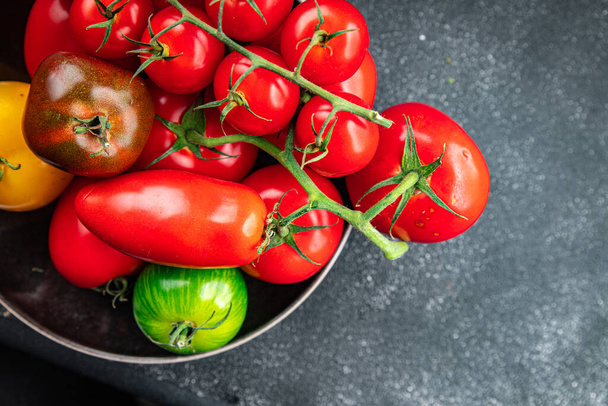 新鮮なトマト野菜品種 赤,黄色,緑のフルーツのアソートトマト 熟した野菜の食事のスナック テーブルのコピー スペース フードの背景 素朴なトップビュー - 写真・画像