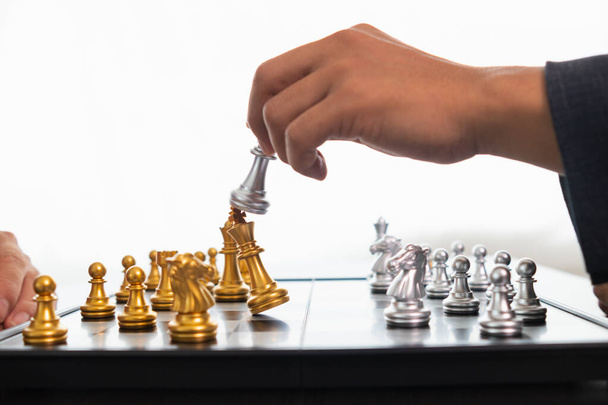 Νεαρός επιχειρηματίας σχεδιάζει να κερδίσει κίνηση σκάκι στο παιχνίδι του σκακιού που αντιπροσωπεύει την επιτυχή και νικηφόρα επιχειρηματική διαδρομή. Σκακιστική ιδέα που αντιπροσωπεύει στρατηγική επιχειρηματική στρατηγική για την επίτευξη νίκης. - Φωτογραφία, εικόνα