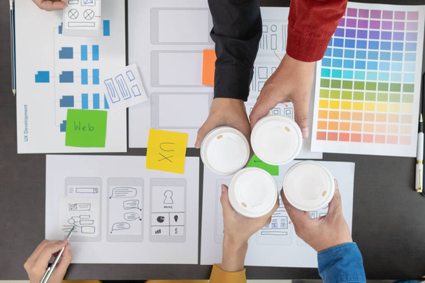 Programmierer und UI-UX-Designer trinken in den Pausen gemeinsam eine Tasse heißen Kaffee im Designstudio, um das Gehirn anzukurbeln, bevor eine weitere Runde gestartet wird. Design Team Kaffeepause-Konzept - Foto, Bild