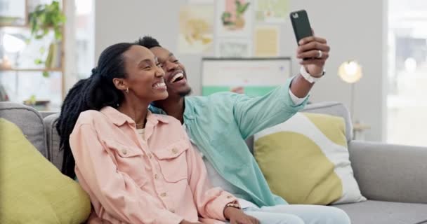 Selfie, pareja de mañana o negro en las redes sociales para relajarse juntos en casa en el sofá de la sala de estar. Abrazo, mujer u hombre feliz tomando fotos o fotos para unirse con amor, apoyo o sonrisa en un post en línea. - Metraje, vídeo