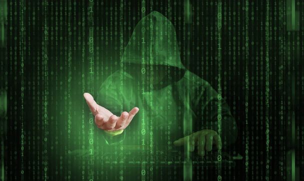 Een hacker achter binaire code, stroom van gegevens, in staat om door cyber security te breken en reikt zijn hand uit om uw persoonlijke identiteit te stelen - Foto, afbeelding