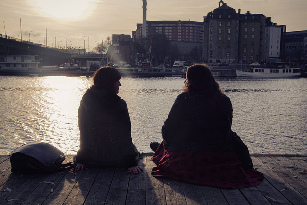 δύο γυναίκες που κάθονται δίπλα στο ποτάμι  - Φωτογραφία, εικόνα
