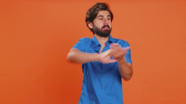 Young middle eastern man showing wasting, throwing money around, more tips, big profit, winning lottery jackpot, successful shopping payment purchase cashback. Guy isolated on orange studio background - Footage, Video