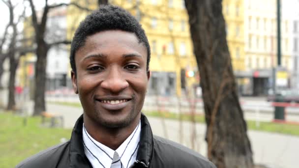 junger schöner schwarzer Mann lächelt - Stadtstraße mit Autos - Stadt - Nahaufnahme - Filmmaterial, Video