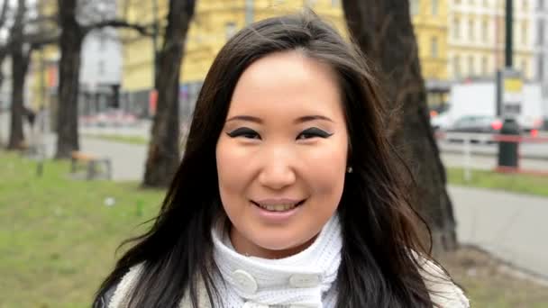 Mladá atraktivní asijské žena úsměvy - městské ulice s automobily - město - detail - Záběry, video