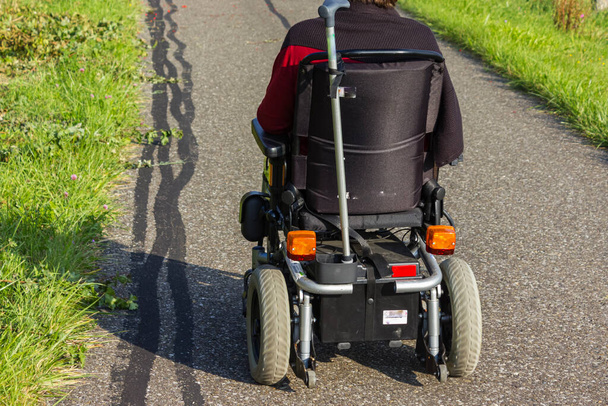 silla de ruedas con motor al lado de una carretera en verano en Alemania - Foto, imagen