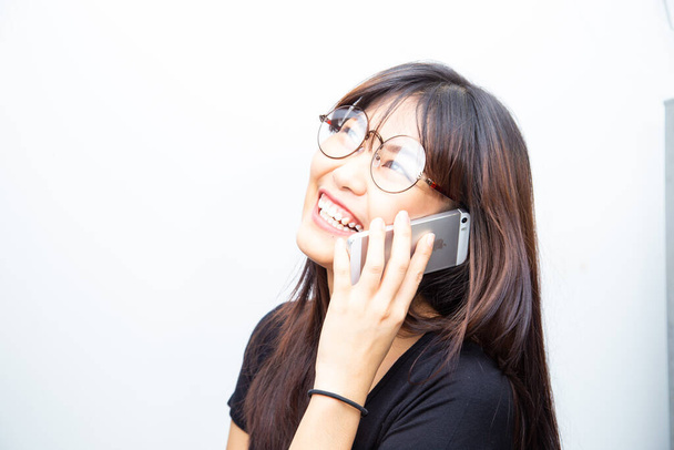 Alegre negocio asiático mujer en casual camisa hablando en smartphone en blanco fondo - Foto, imagen