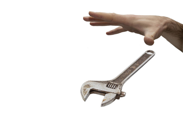 Male hand dropping an adjustable wrench, soft focus close up isolated on white, job ending concept - Photo, Image
