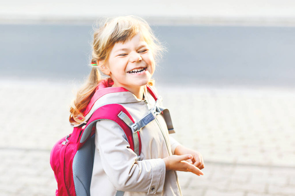 Χαριτωμένο κοριτσάκι που πάει σχολείο. Υγιές παιδί μικρής ηλικίας με τα πόδια στο νηπιαγωγείο και νηπιαγωγείο. Ευτυχισμένο παιδί με σακίδιο πλάτης στο δρόμο της πόλης, σε εξωτερικούς χώρους - Φωτογραφία, εικόνα