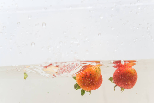 Świeży truskawka Splash w wodzie na białym tle - Zdjęcie, obraz