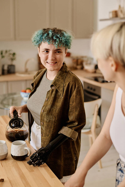 Immagine verticale di fidanzate che parlano tra loro mentre bevono caffè in cucina - Foto, immagini