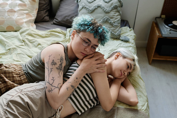 Leszbikus nők fekszenek az ágyban, és élvezik az együtt töltött időt otthon - Fotó, kép