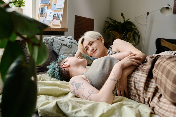 Lovely lesbian women lying on bed and spending time at home - Foto, Imagem