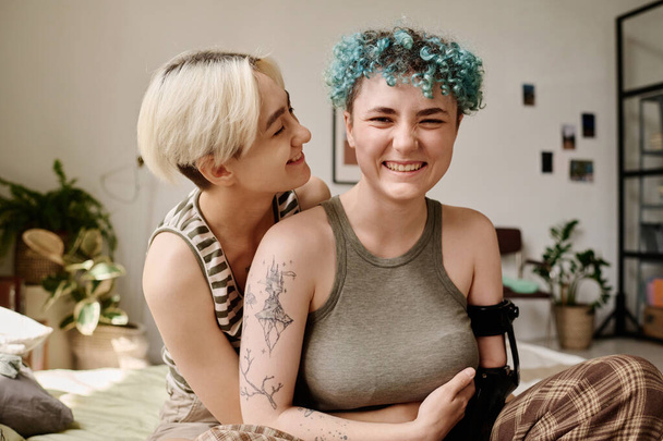 Happy lesbian girls embracing while spending time in the room - Photo, Image