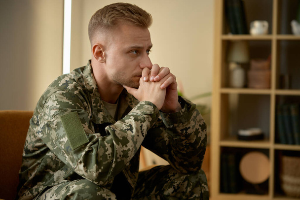Zbliżenie zdenerwowanego żołnierza w mundurze wojskowym myślącego o swoim zdrowiu psychicznym. Psychoterapia i zagadnienia społeczne - Zdjęcie, obraz