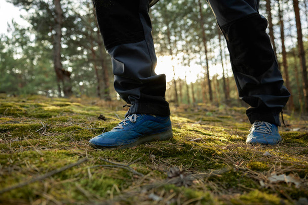 Nahaufnahme Wanderer zu Fuß in Trekkingstiefeln auf einem Waldweg. Aktive Lebensweise und Achtsamkeit während der Waldbegehung - Foto, Bild