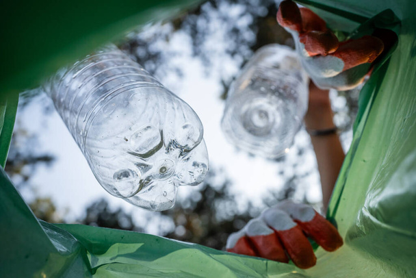 POV άποψη από το εσωτερικό της τσάντας νεαροί εθελοντές έφηβοι συλλέγουν πλαστικά απόβλητα από τη φύση οικολογική συνείδηση και ανακυκλώνουν έννοια - Φωτογραφία, εικόνα