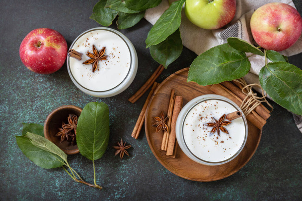 Autumn still life Background. Healthy nutrition: apple smoothie with cinnamon on a dark stone background. View from above.  - Photo, Image