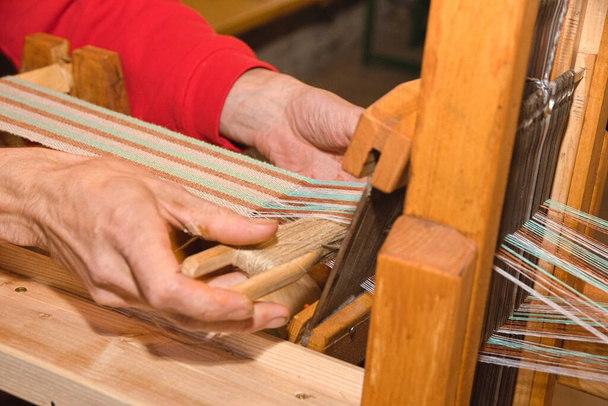 Тканина для плетіння людини за допомогою дерев'яного столового ткацького верстата крупним планом - Фото, зображення