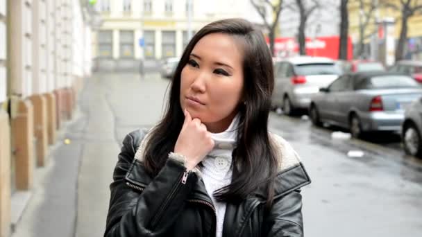 Jonge aantrekkelijke Aziatische vrouw denkt - stedelijke straat met auto's - stad - Video
