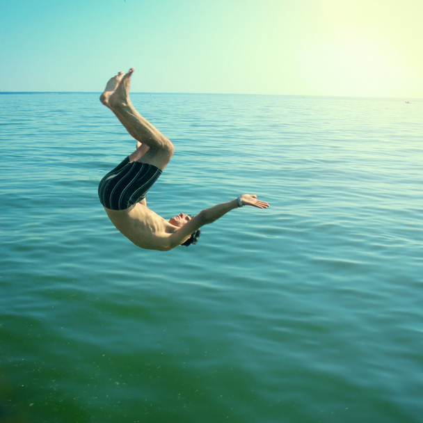Jeune homme sautant dans la mer
 - Photo, image
