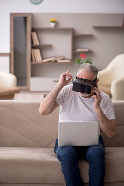 У віці чоловік насолоджується віртуальними окулярами вдома
 - Фото, зображення