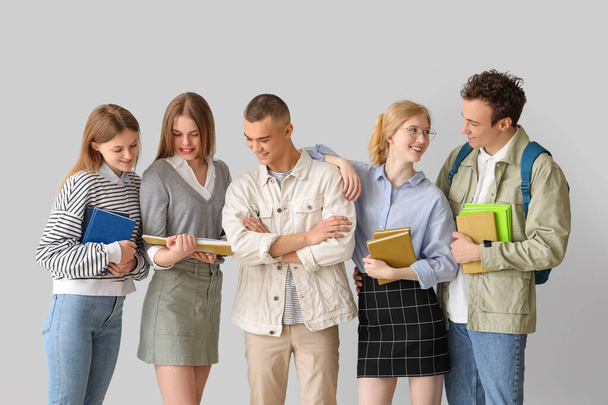 Studentengruppe mit Büchern auf grauem Hintergrund - Foto, Bild