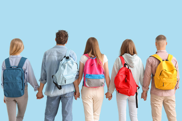 Groupe d'étudiants avec sacs à dos sur fond bleu - Photo, image