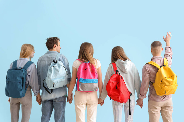Группа студентов с рюкзаками на синем фоне - Фото, изображение