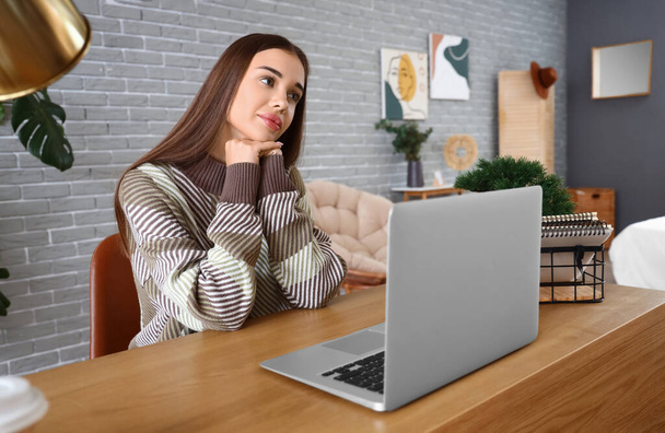 Молода жінка з ноутбуком відео балакає за столом в офісі - Фото, зображення