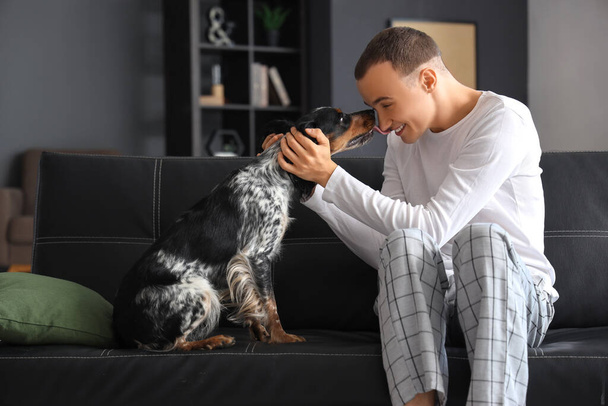 Young man with cute cocker spaniel sitting on couch at home - Photo, Image