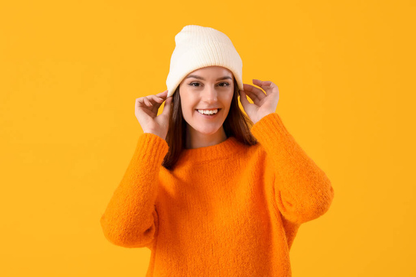 Young woman in winter clothes on yellow background - Foto, Imagem