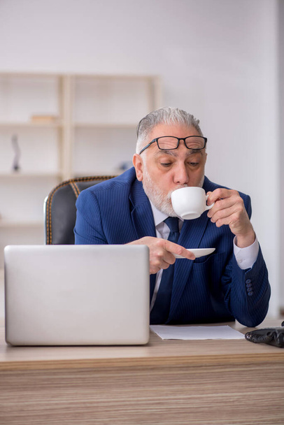 Vanha työntekijä juo kahvia tauon aikana - Valokuva, kuva
