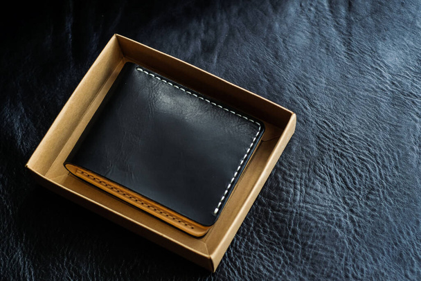 Λαχανικό δερμάτινο πορτοφόλι σε μαύρο δερμάτινο φόντο, Χειροτεχνία αντικείμενο - Φωτογραφία, εικόνα
