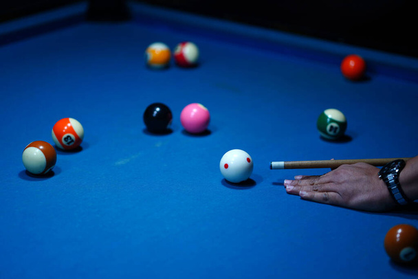 A kéz kezében a biliárddákó, készen áll, hogy egy pontos sztrájk a biliárd labdát a biliárd asztal egy játék a biliárd. Sport és játék fotózás. - Fotó, kép