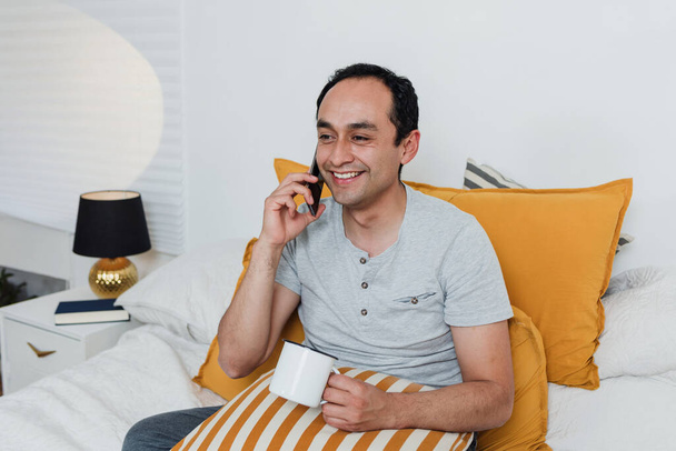 latino falando ao telefone na cama em casa no México América Latina, hispânicos - Foto, Imagem