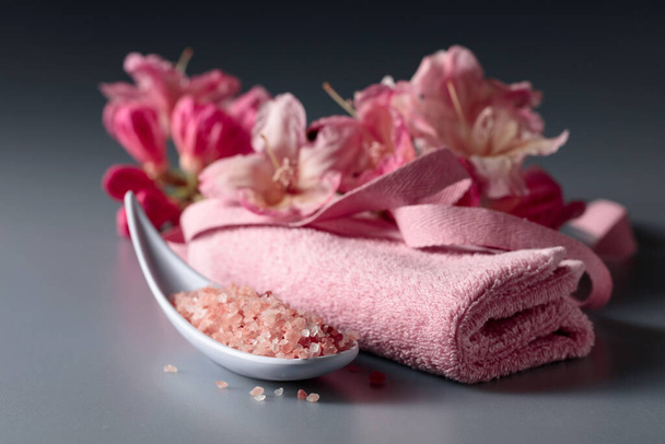 Composition du spa avec du sel rose de l'Himalaya, des fleurs et une serviette. - Photo, image
