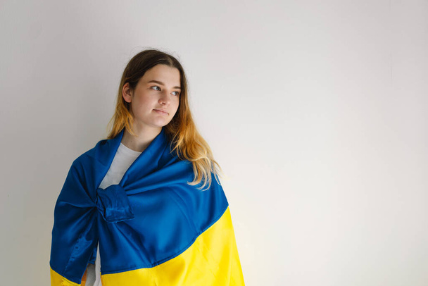 Portret nastolatki z ukraińską flagą na białym tle. Styl życia. Przestrzeń kopiowania - Zdjęcie, obraz