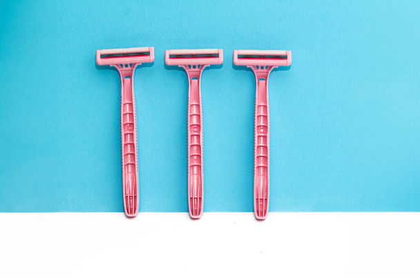 Afeitadoras de señora rosa, maquinillas de afeitar sobre fondo blanco, azul - Foto, imagen