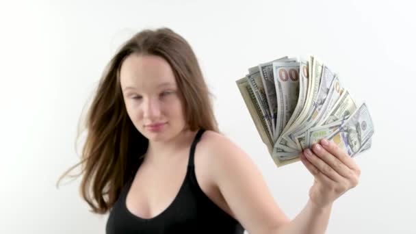 Молода щаслива жінка в сірому светрі, яка тримає гроші і дивиться на камеру. Високоякісні 4k кадри - Кадри, відео