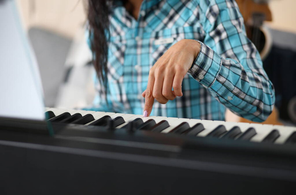 Зосередьтеся на синтезаторі жіночої руки в музичній студії. Професійний милий піаніст вивчає нову музичну композицію. Художньо-музична концепція. Розмитий фон
 - Фото, зображення