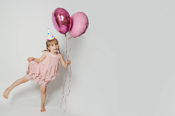 Criança feliz com balão rosa no fundo do banner da parede do estúdio branco - Foto, Imagem