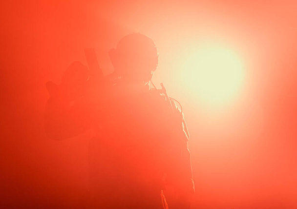 Żołnierz z bronią stojący w gęstej mgle z bronią, tajemnicza sylwetka - Zdjęcie, obraz