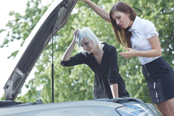 atrakcyjne kobiety w pobliżu uszkodzonego samochodu - Zdjęcie, obraz