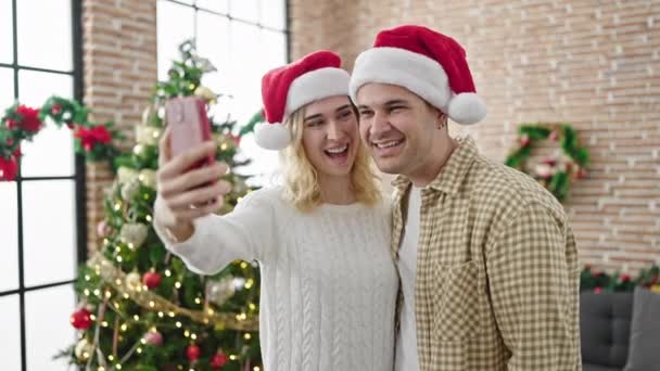 mężczyzna i kobieta para świętuje Boże Narodzenie mając wideo połączenie w domu - Materiał filmowy, wideo
